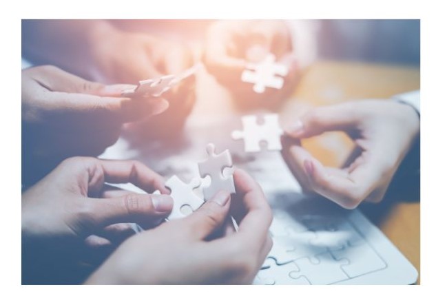 Picture of hands putting a puzzle together.